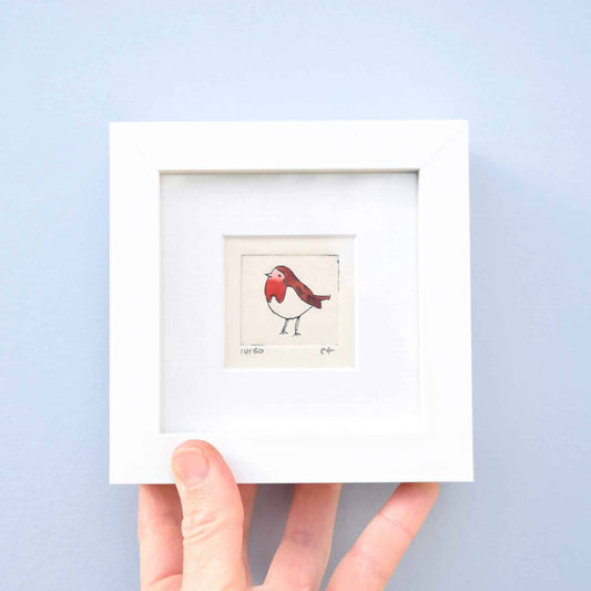 Robin standing tall and facing left - mini collagraph print in a white frame