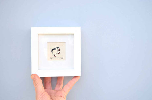 Dancing puffin, facing right - mini collagraph print in a white frame